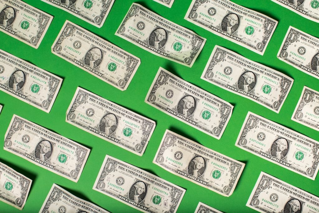Green background with American dollar bills on top