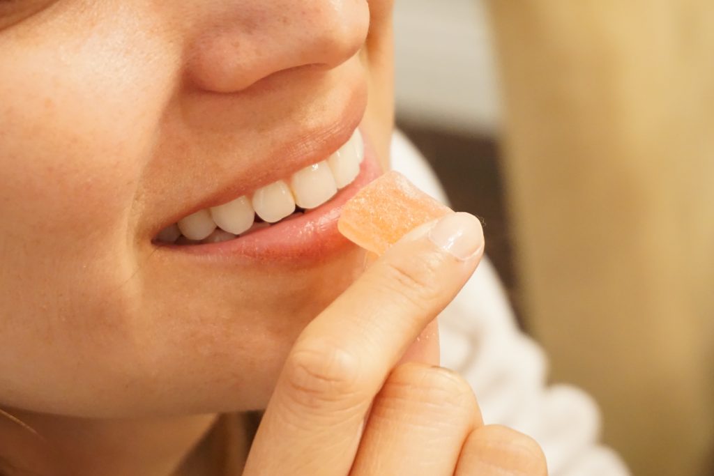woman eating delta-10 thc gummy orange